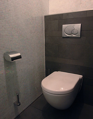 Abgetrennte WC-Anlage im Fertigbad mit Schieferfliesen und Glasmosaik.