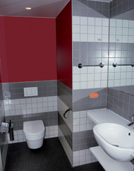 Ausführung der Bäder mit farblichen Designelementen in rubinrot, purpurrot und orange.