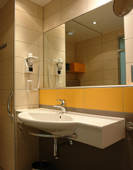 Waschbereich mit fliesenbündigen Spiegel.