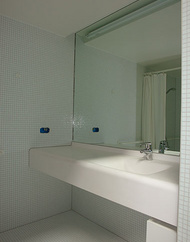 Waschtischbereich mit fliesenbündigen Spiegel und verdeckter Beleuchtung