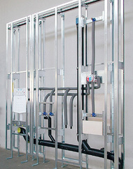 Installationswand mit WC-, Waschtisch- und Brauseeinheit,Kopf- und Fußbrauseanschuss sowie Abfluss mit Rohrbelüfter.